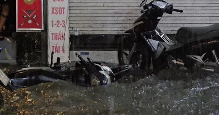 Nước tràn vào nhà xối xả, xe máy nổi lềnh bềnh trên phố trong cơn mưa lớn